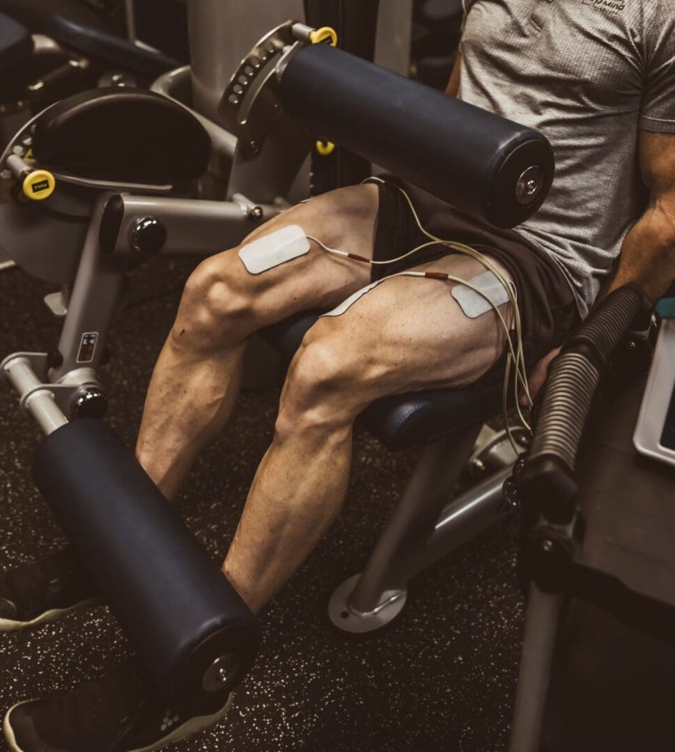 Man using leg extension machine at gym.