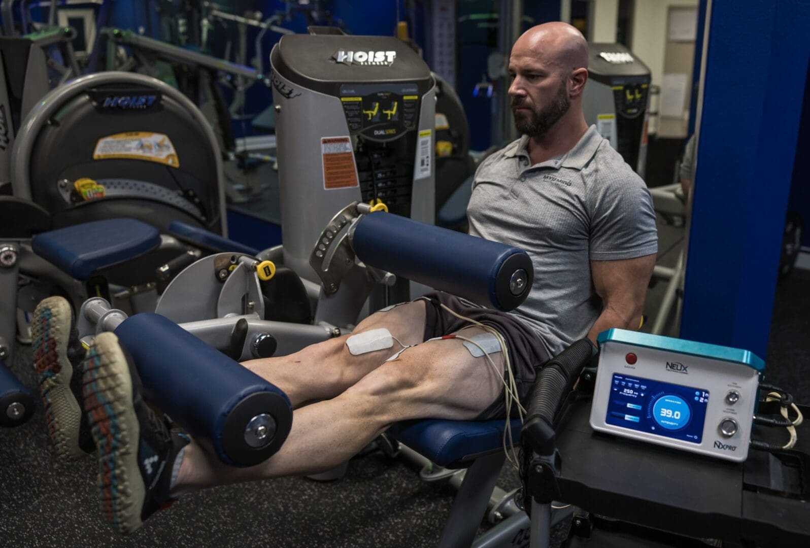 Man using electrical muscle stimulation machine.